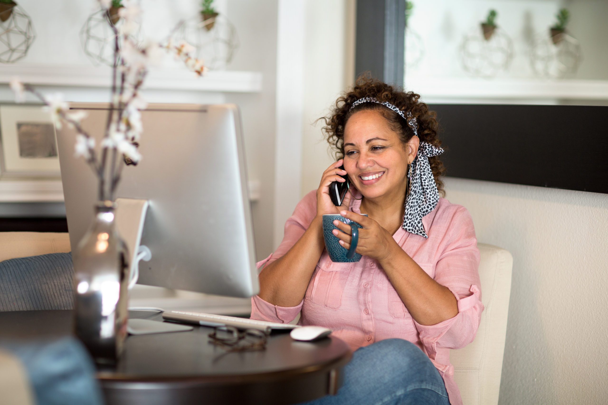 Mixed race woman working from her home office. Happy woman working from her home office.